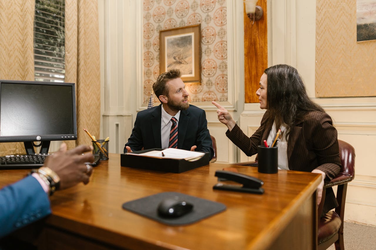 home-hero Professionals engaged in a serious discussion inside a law office with a computer on the desk.